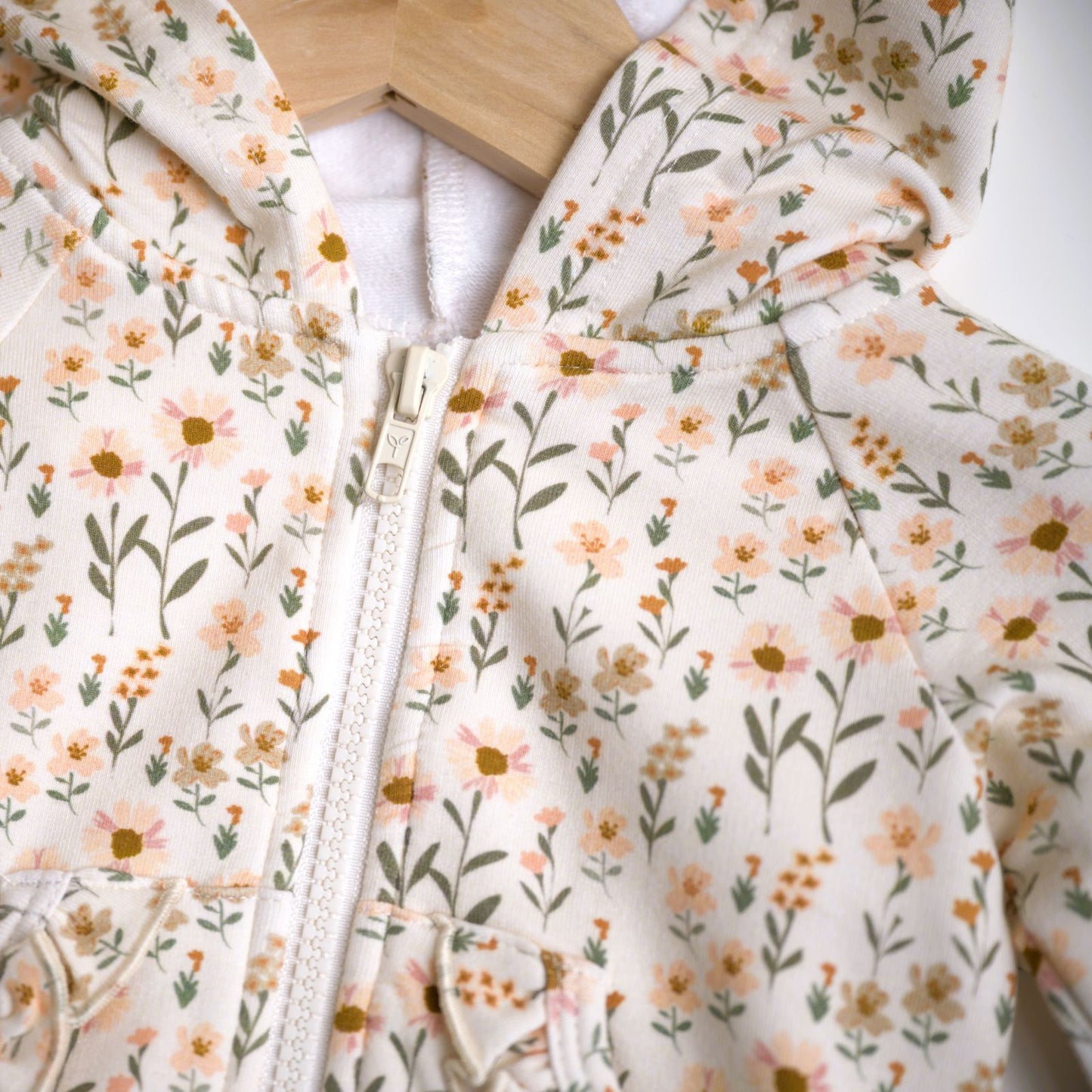 Babysprouts girl's hooded jacket with a floral daisy pattern in various colors primarily in white and pink, with a drawstring hood.