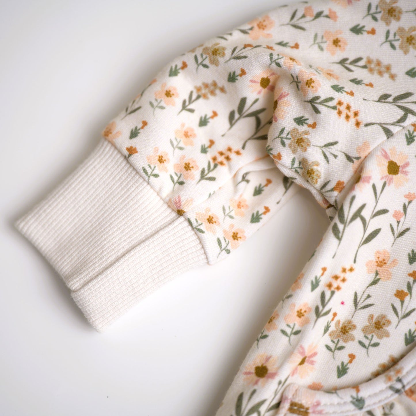 Babysprouts girl's hooded jacket with a floral daisy pattern in various colors primarily in white and pink, with a drawstring hood.
