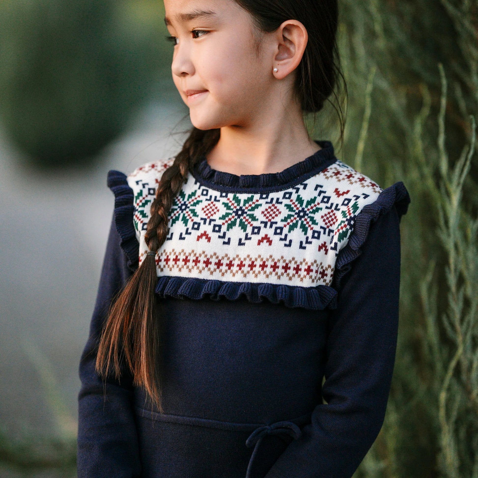 young girl wearing Hope & Henry organic ruffle collar sweater dress in Scottish snowflake pattern