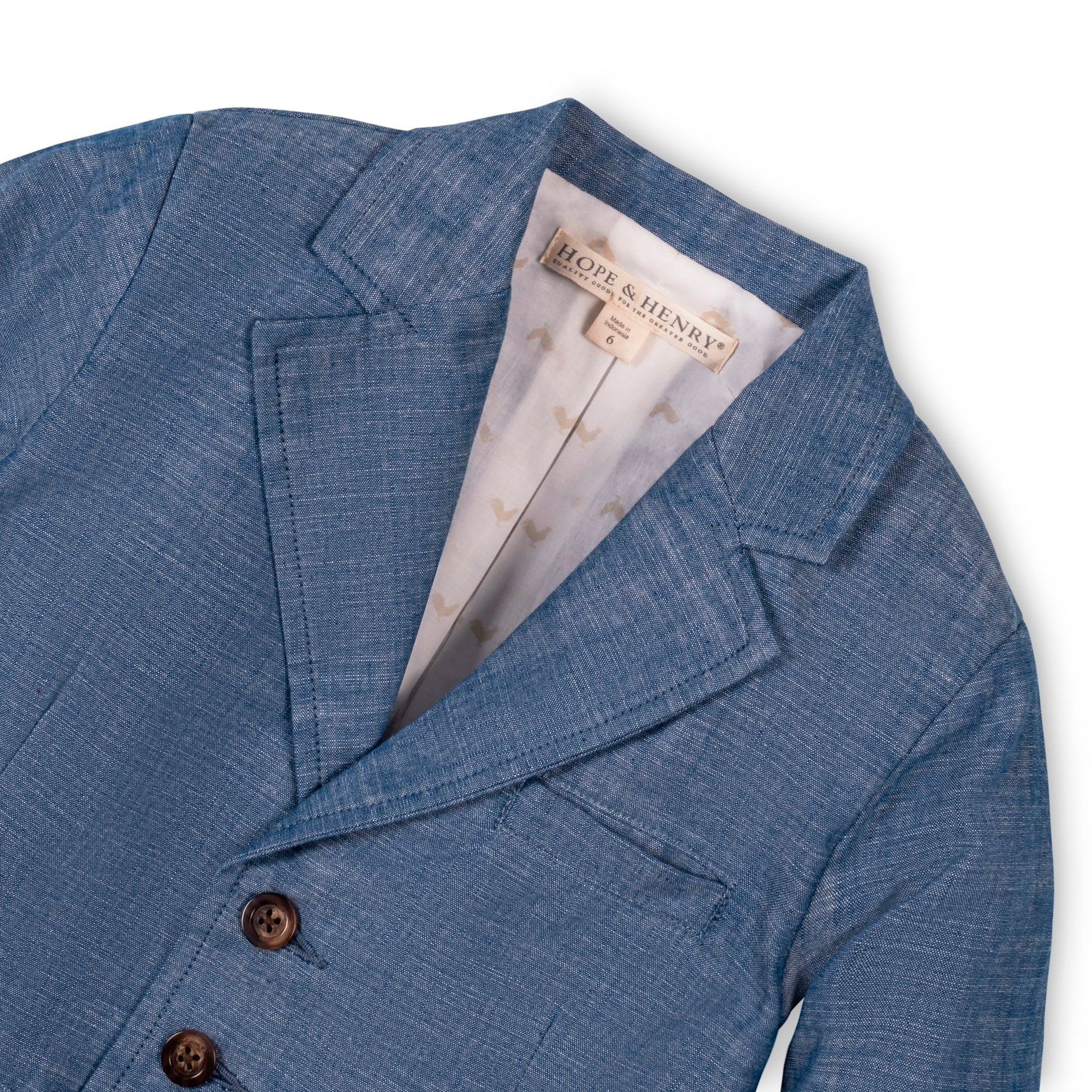 Blue chambray blazer with a visible brand tag on a white background