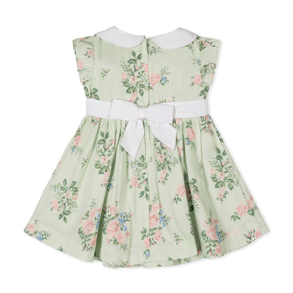 Green floral baby dress with pink and blue floral pattern with white collar on a white background