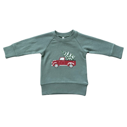 Green sweatshirt with a red truck graphic on a white background