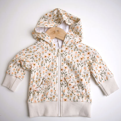 Babysprouts girl's hooded jacket with a floral daisy pattern in various colors primarily in white and pink, with a drawstring hood.