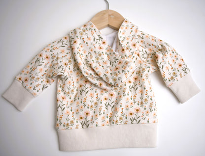 Babysprouts girl's hooded jacket with a floral daisy pattern in various colors primarily in white and pink, with a drawstring hood.