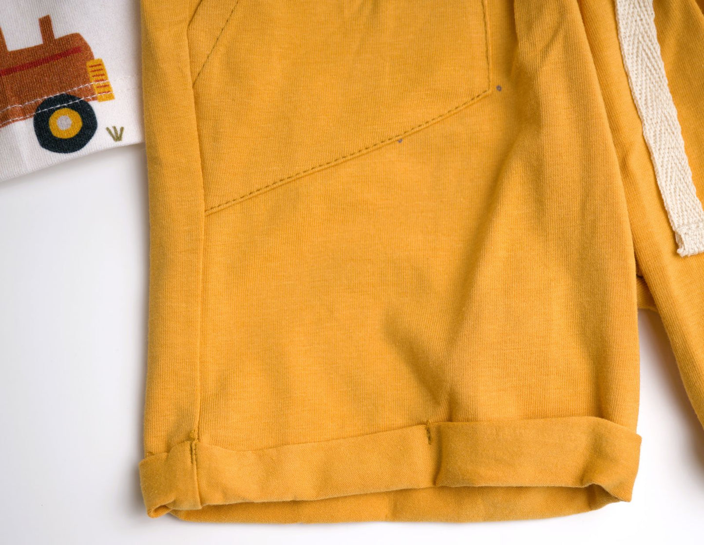 Viverano Organics baby playsuit set with a farm animal print, including a sleeveless tee and shorts in orange, with a white sash tie at the waist.