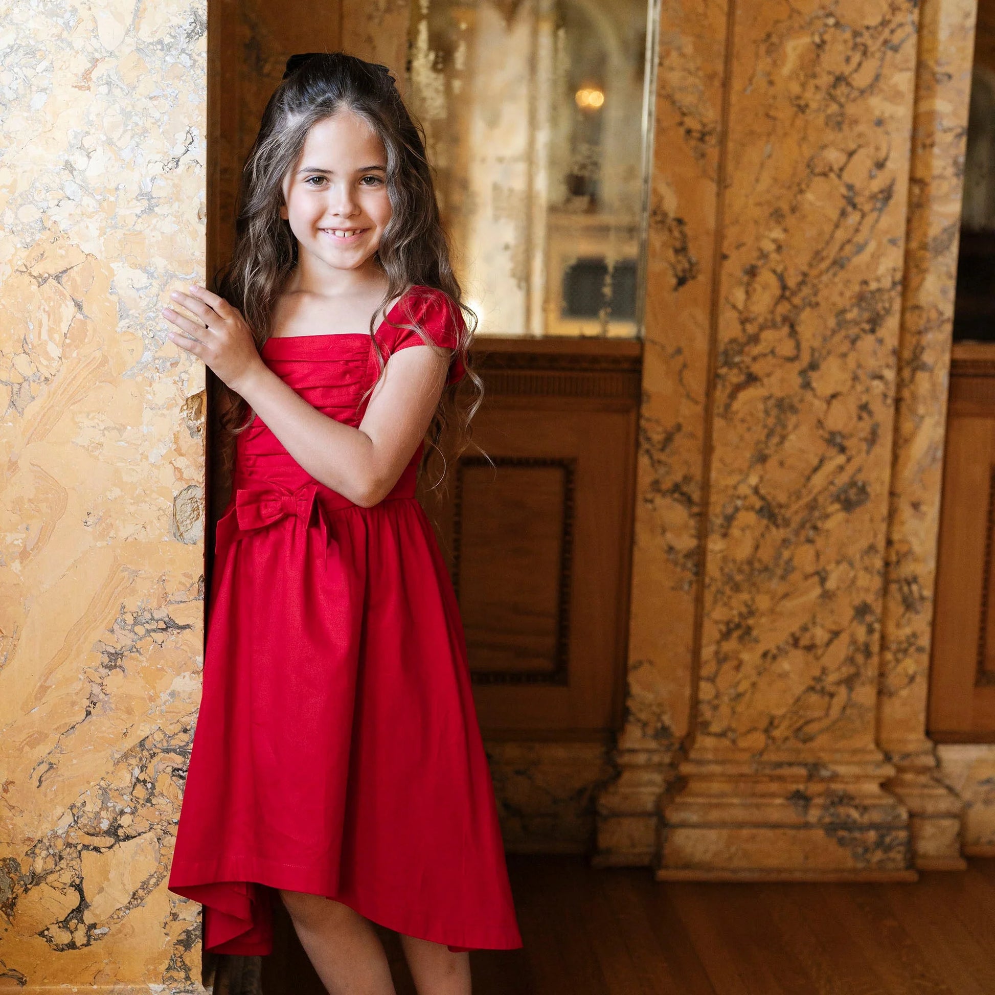 young girl wearing Hope & Henry organic red high low sateen dress for Christmas