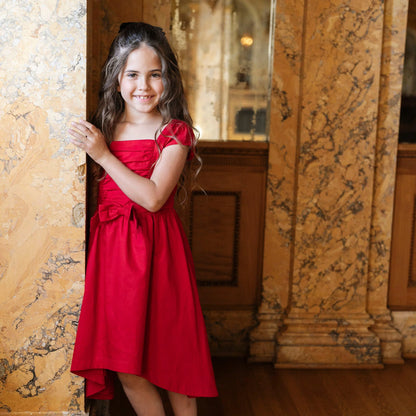 young girl wearing Hope & Henry organic red high low sateen dress for Christmas