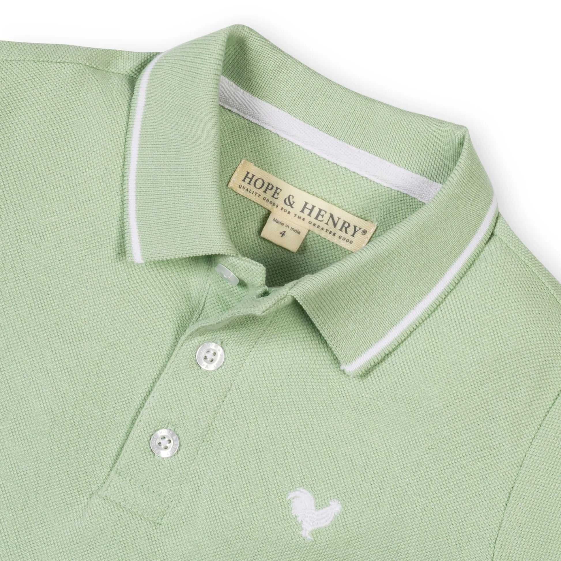 Collar view of a boys bright green organic cotton pique polo shirt by Hope and Henry.