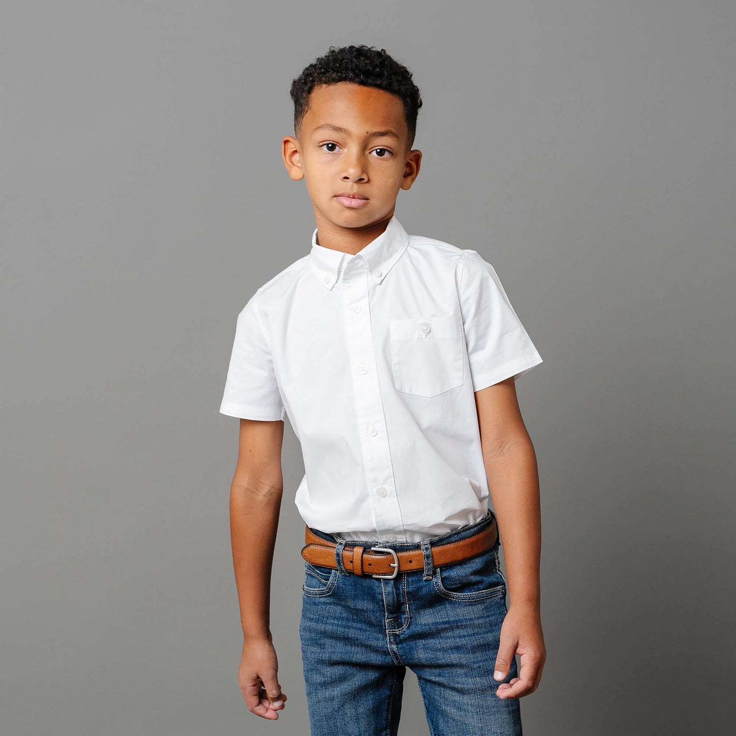 boy wearing Boys white short sleeve organic cotton stretch poplin button-down shirt by Hope and Henry.