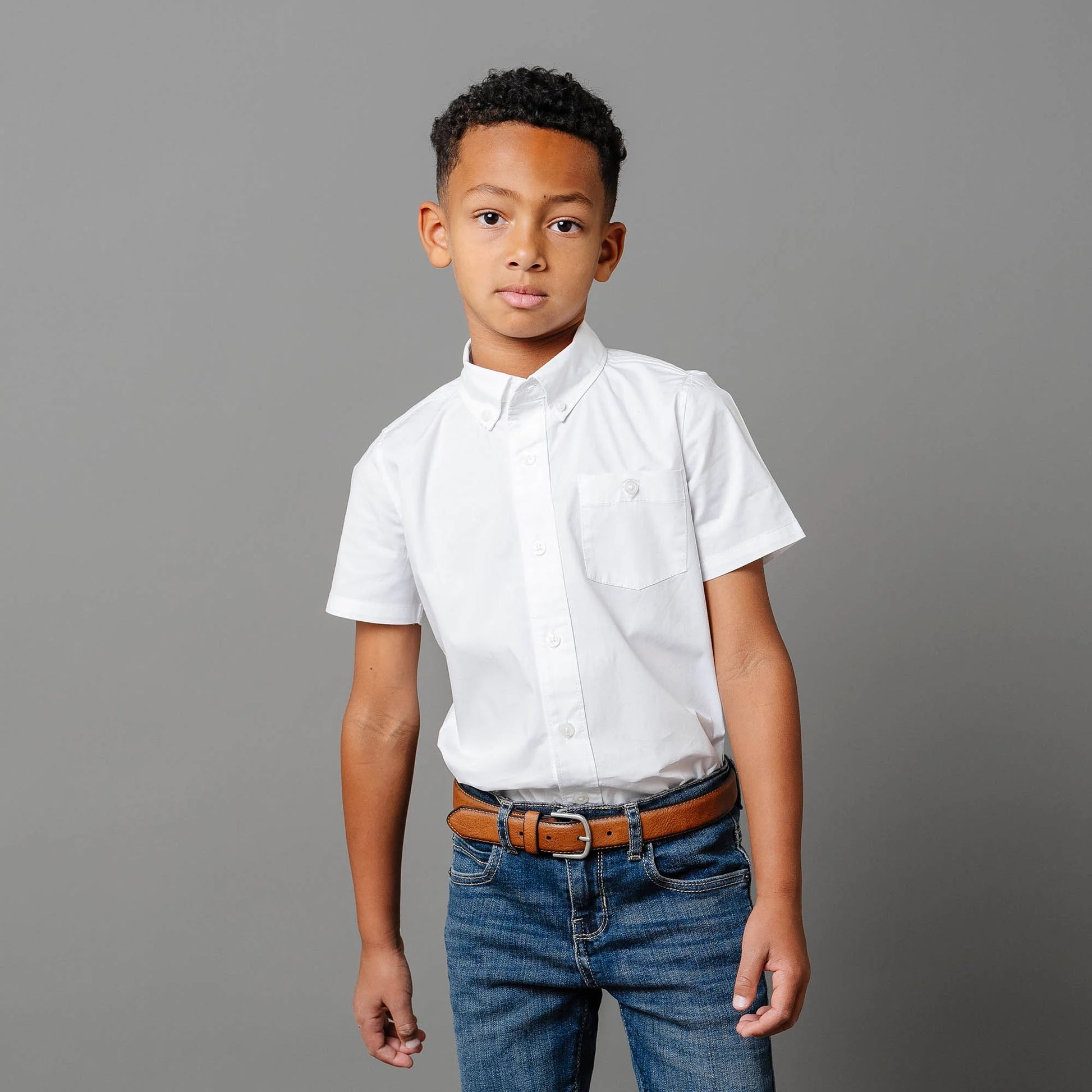 boy wearing Boys white short sleeve organic cotton stretch poplin button-down shirt by Hope and Henry.